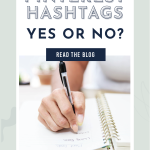 Close-up of a hand writing in a notebook with text above reading "Pinterest Hashtags: Yes or No?" and "Read the Blog." Calm, focused tone.